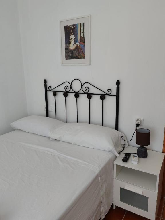 Double room with wrought iron bed and bedside table